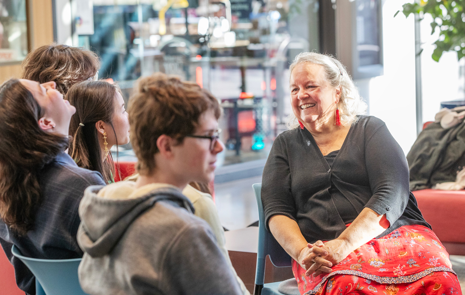Author Robin Wall Kimmerer smiles while talking informally with several students