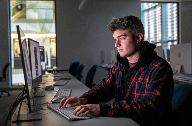 Dylan Telano works at a computer in a Skidmore computer lab